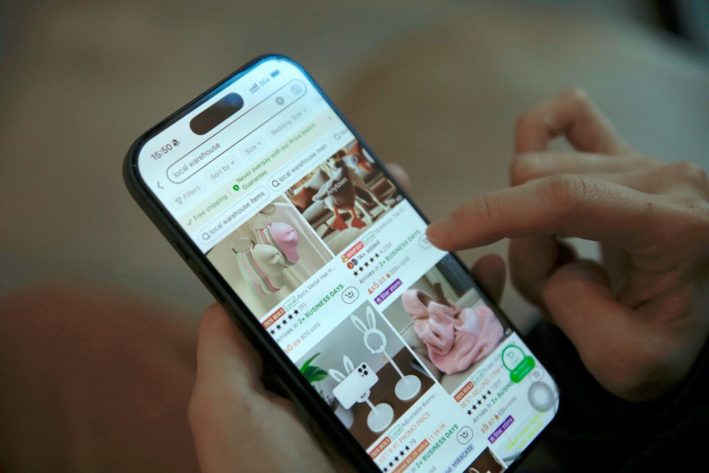 スマートフォンでショッピングのフィードをスクロールする手元