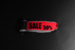 黒い背景に置かれた50%OFFと書かれた赤いセールタグ